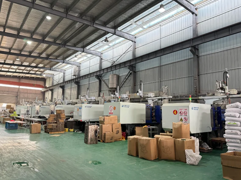 Injection molding line — long row of Haitian injection machines with safety signage in production hall